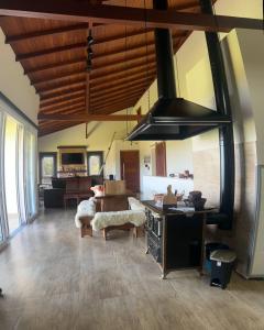 a living room with a kitchen with a stove at Casa em condomínio rural in Rancho Queimado