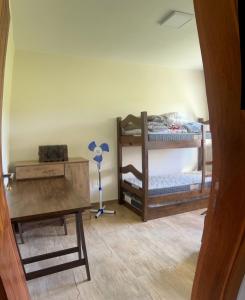 a room with two bunk beds and a desk at Casa em condomínio rural in Rancho Queimado