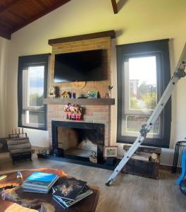 a living room with a fireplace with a tv at Casa em condomínio rural in Rancho Queimado +41 photos