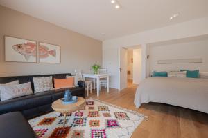 ein Wohnzimmer mit Sofa und Bett in der Unterkunft Kleine Perle in Kampen