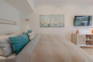 ein Wohnzimmer mit Sofa und Flachbildfernseher in der Unterkunft Kleine Perle in Kampen