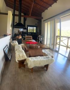 a living room with couches and tables in a room at Casa em condomínio rural in Rancho Queimado