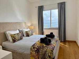 a bedroom with a bed and a large window at Welcome to Paradise Island in Caniço