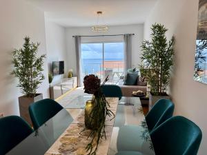 a living room with a table and green chairs at Welcome to Paradise Island in Caniço