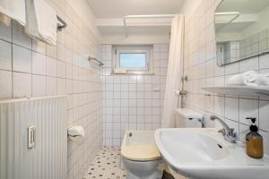 une salle de bain blanche avec un lavabo et des toilettes dans l'établissement Ferienwohnung am Bächler, à Hagnau am Bodensee