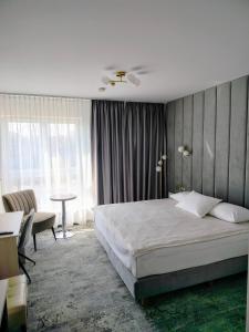 a bedroom with a bed and a desk and a table at Hotel Sokołowska Airport Modlin in Nowy Dwór Mazowiecki