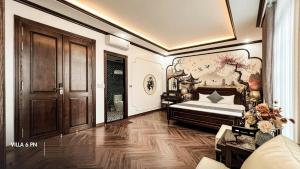 une chambre avec un lit et un tableau au mur dans l'établissement Biệt Thự HL Near Beach, à Hạ Long