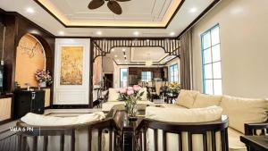 un salon avec un canapé et une table avec des fleurs dans l'établissement Biệt Thự HL Near Beach, à Hạ Long 2 autres photos