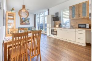 a kitchen with a table and chairs and a dining room at Ferienwohnung SeeNest am Röbeler Stadthafen - Neubau 2025 in Röbel