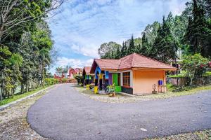 een klein huis aan de kant van een weg bij Hotel O Taman Wisata Iman Ii Near Taman Wisata Iman Sitinjo in Hutamanik