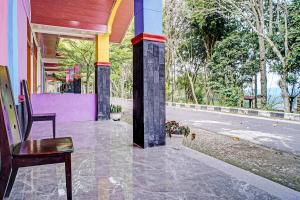 een stoel op de veranda van een gebouw bij Hotel O Taman Wisata Iman Ii Near Taman Wisata Iman Sitinjo in Hutamanik +18 foto's