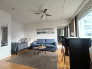 a living room with a blue couch and a piano at EP City Suite - Sauna, Balcony & Free parking in Tampere +10 photos