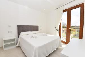 a white bedroom with a bed and a window at Casa Emma in Agerola