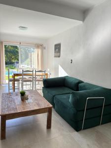 a living room with a green couch and a table at Flores del Cerro in Tandil