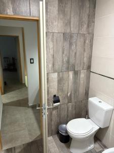 a bathroom with a toilet and a hallway at Flores del Cerro in Tandil