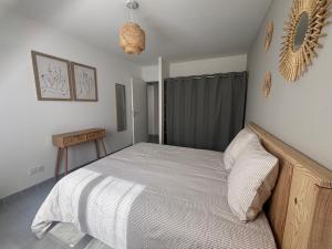 a bedroom with a bed with a wooden frame at Maison neuve classement 3 étoiles avec accès privé piste cyclable, 6 personnes in Mimizan