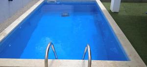 a large blue swimming pool with two metal at Kuća za odmor Mumi in Gostinjac