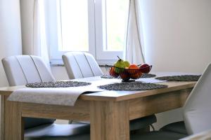 a dining room table with a bowl of fruit on it at Kuća za odmor Mumi in Gostinjac