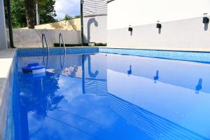 a blue swimming pool with a reflection in the water at Kuća za odmor Mumi in Gostinjac