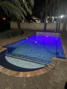 a swimming pool with purple lighting at night at The Loraine Luxury Villa in Witbank