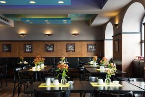 a restaurant with tables and chairs with flowers on them at Hotel Deutsches Theater Stadtzentrum in Munich