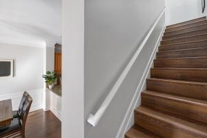 een trap in een huis met witte muren en houten vloeren bij King and Queen Beds with a Gourmet Kitchen in Charlotte