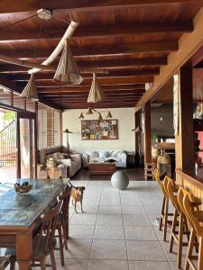 a dog standing in a living room with a table at Aroeiraecocasa in Morro de São Paulo