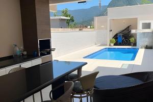 Casa c/ piscina em Cond, Boraceia - SP في بوراسيا: مطبخ وغرفة معيشة مع مسبح