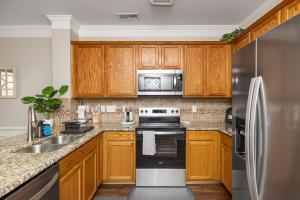 een keuken met houten kasten en een roestvrijstalen koelkast bij King and Queen Beds with a Gourmet Kitchen in Charlotte