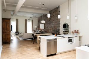 an open kitchen and living room with a brick wall at Maison Place Jacques-Cartier by Luxury In Transit in Montréal