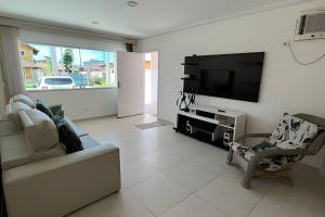 Casa c/ piscina em Cond, Boraceia - SP في بوراسيا: غرفة معيشة مع أريكة وتلفزيون