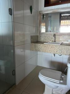 a bathroom with a toilet and a sink and a mirror at Aroeiraecocasa in Morro de São Paulo