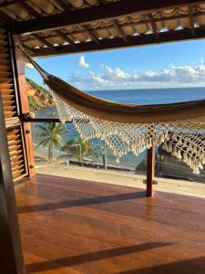 a view of the ocean from a room with a hammock at Aroeiraecocasa in Morro de São Paulo