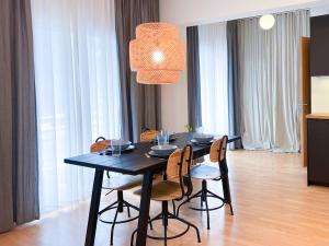 tavolo nero da pranzo con sedie e luce di distillazione di Downtown Apartment a Kavala