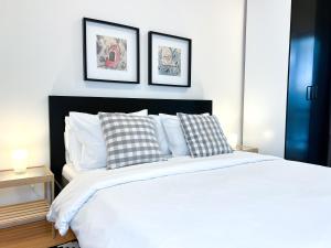 una camera con un letto bianco con due immagini sul muro di Downtown Apartment a Kavala