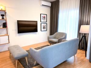 un soggiorno con divano, 2 sedie e TV di Downtown Apartment a Kavala