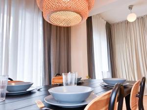 una sala da pranzo con tavolo, sedie e lampadario pendente di Downtown Apartment a Kavala Altre 19 foto