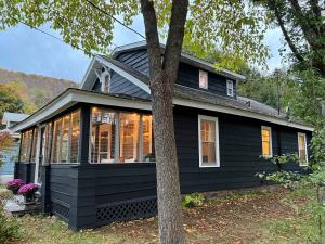 a black house with a tree in front of it at Phoenicia Bungalow in Phoenicia