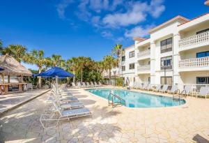 a resort pool with lounge chairs and an umbrella at Hampton Inn & Suites St. Augustine-Vilano Beach in St. Augustine