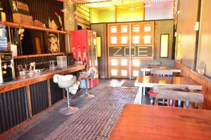 een restaurant met een bar met tafels en stoelen bij ZOE LODGE in Renaico