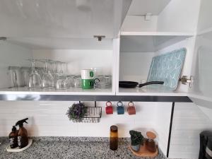 a kitchen with a shelf with glass items on it at Central Location 2 Bedroom Apt in Antalya