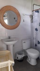 a bathroom with a toilet and a sink and a mirror at Casaecologica en pleno centro con jardin y arbolesfrutales in Tarapoto