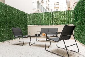 two chairs and a table in front of a green wall at WYZ Museum by UPSTREET in Athens