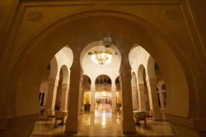 an empty hallway with chairs and a chandelier in a building at Hotel Nour Palace Resort & Thalasso Mahdia in Mahdia