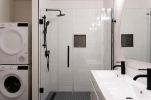 a bathroom with a shower and a washing machine at Maison Place Jacques-Cartier by Luxury In Transit in Montréal +108 photos