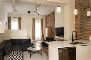 a living room with a couch and a kitchen at Maison Place Jacques-Cartier by Luxury In Transit in Montréal
