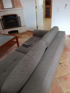 a large gray couch in a living room with a fireplace at Albufeira INN - Mulatinho V2 in Olhos de Água