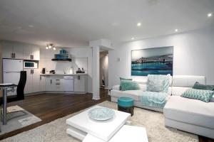 a living room with a white couch and a kitchen at Tranquille Discret Privé in Laval