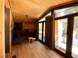 a living room with large windows and a couch at Chalet l'Epicéa T3 sous les pins avec Jardin à 5 min à pied des pistes P2 et commerces in Bolquere Pyrenees 2000