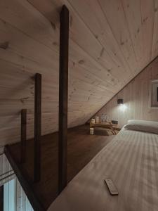 a bed in a room with wooden walls at Bonanza Terra in Rukliai